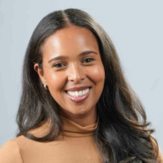 Photo of Selam Nicola in a light brown sweater against a gray background