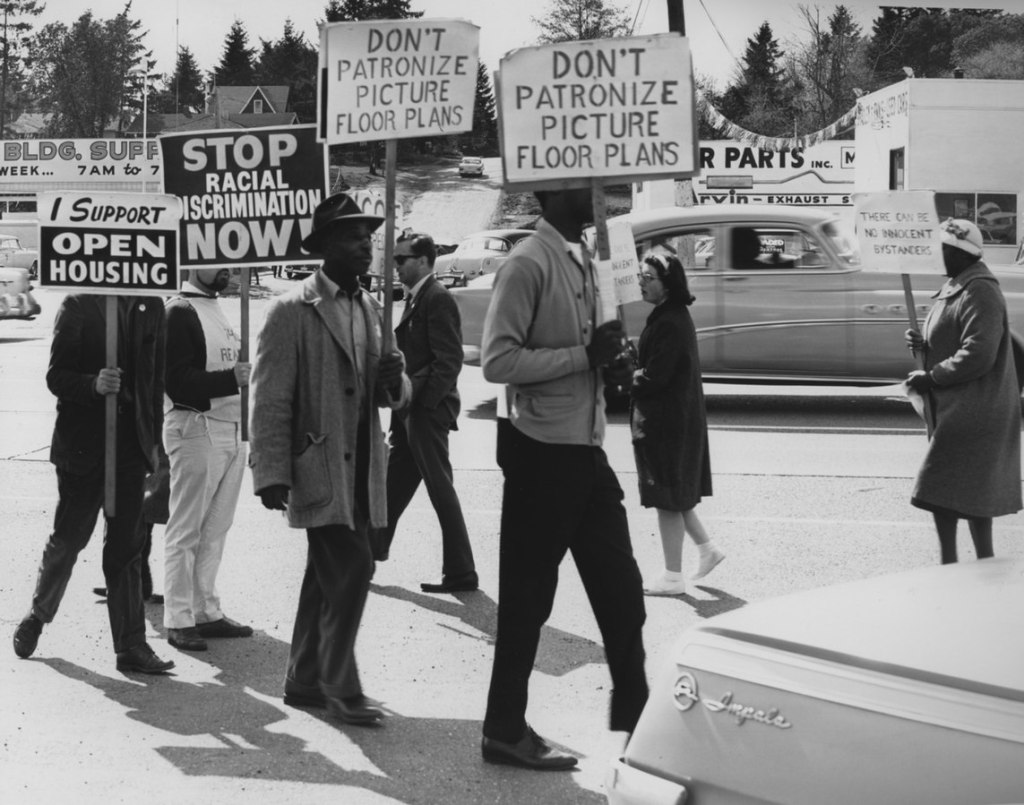 Image shows protesters holding signs in support of fair housing in Lake City, Washington