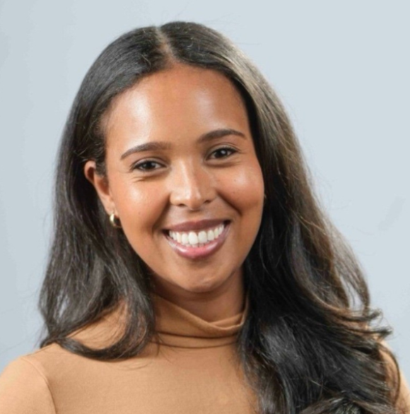 Photo of Selam Nicola in a light brown sweater against a gray background