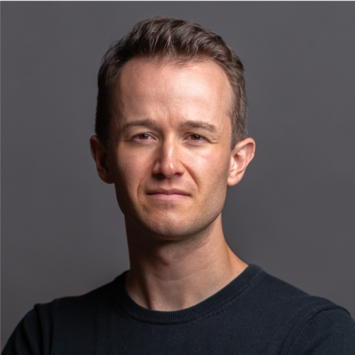 Professional headshot photo of Gabe Brizon-Trezise in a black shirt against a gray background.