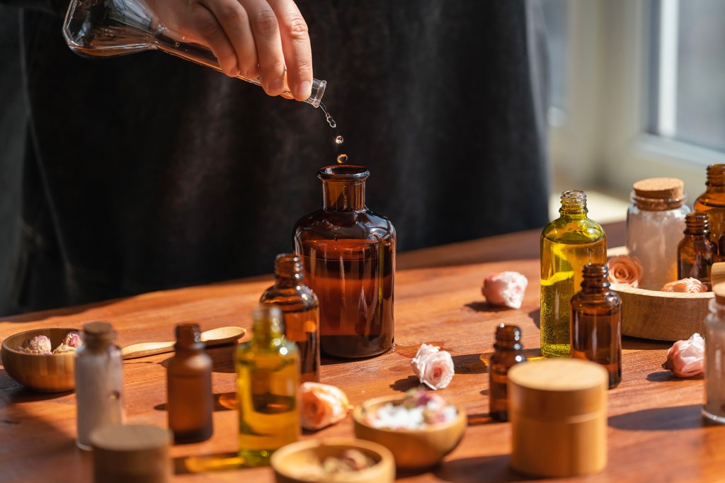 Photograph of a hand pouring a liquid into a bottle