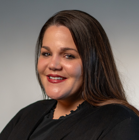 Photo headshot of Alexandrea Adkins in a black top against a gray background.