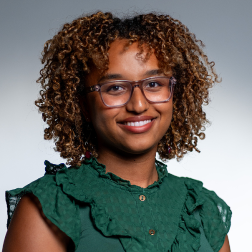 Professional headshot of Mardet Mulugeta in a jewel-toned green blouse and glasses