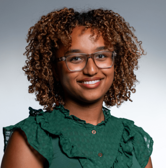 Professional headshot of Mardet Mulugeta in a jewel-toned green blouse and glasses