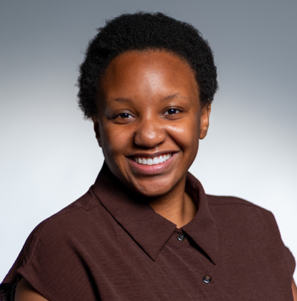 Professional headshot of Rolonda Donelson wearing a brown blouse and smiling against a gray background
